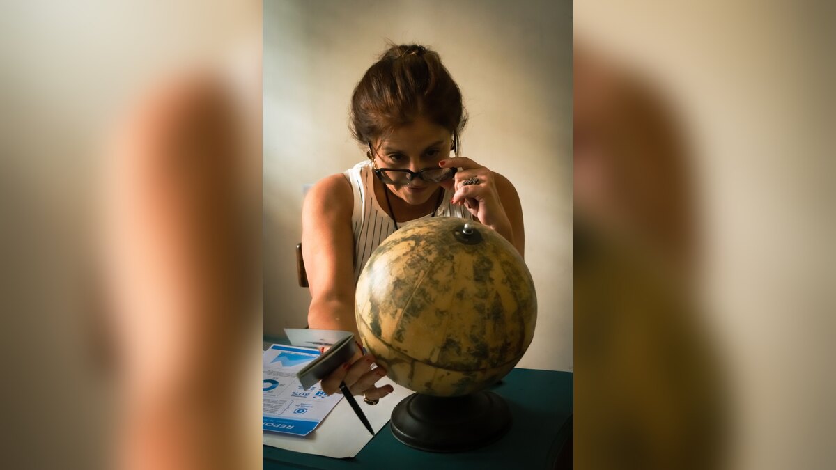 Woman studying a globe and notes at a desk