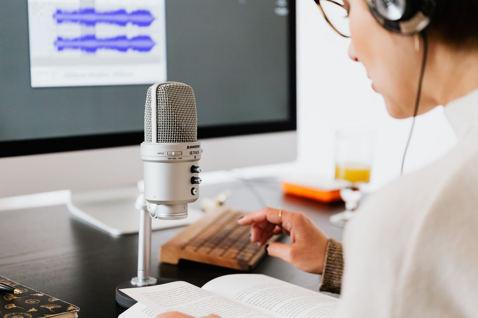 Une personne écoute un livre audio en suivant le texte imprimé et prend quelques notes