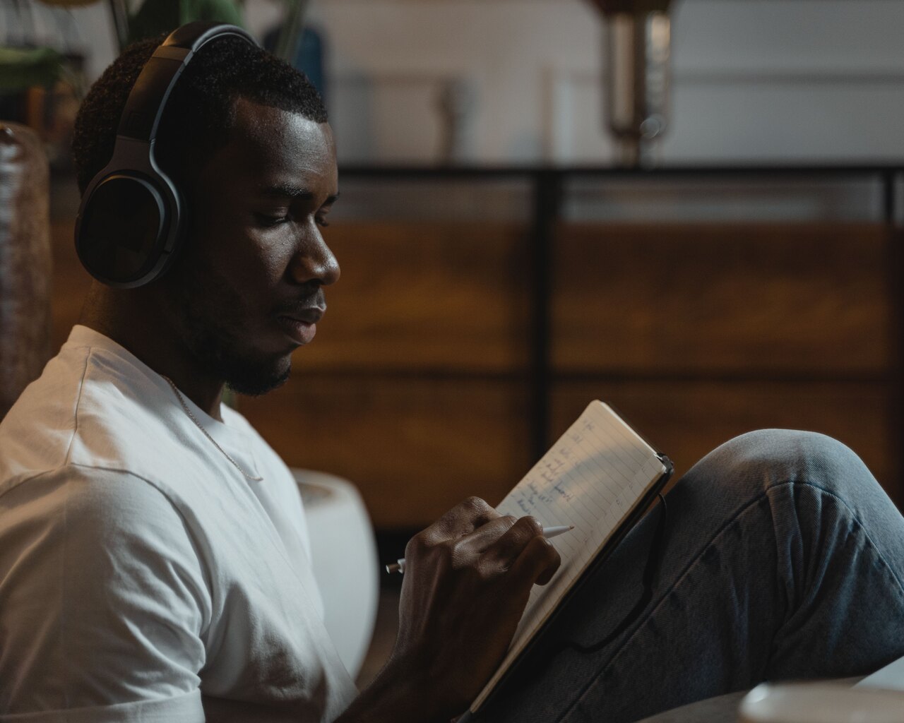 Language learner wearing headphones and reviewing notes